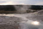 Photo of a landscape with water flowing off of hot springs and out toward a stream